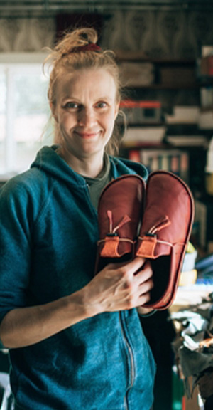 Nanna Nikunen valmistaa käsityönä jaloille kilttejä Hukkasiini-kenkiä.
