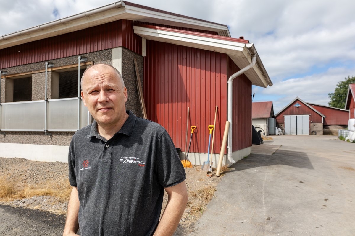Henkilö Sihvoselan navetan ja piharakennusten edustalla.